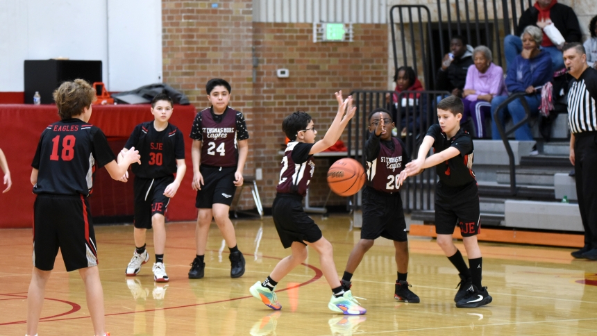 Careron Wilkins (right) of St. John the Evangelist School passes the ball while being swarmed by St. Thomas More School defenders at the Catholic Youth Organization finals hosted on Feb. 9 at Andrean High School in Merrillville. In the battle of the sixth-grade Eagles, SJE of St. John clipped the wings of St. Tom's of Munster. This year's annual CYO tournament was expanded to include fourth-grade teams, making it a five-grade event. (Anthony D. Alonzo photo)