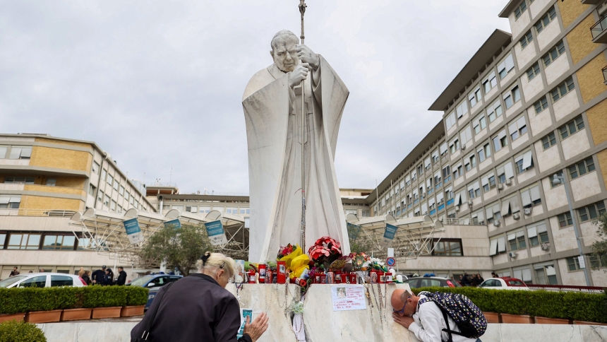 A man and woman pray by the statue of St. John Paul II outside Rome's Gemelli Hospital March 14, 2025, where Pope Francis was admitted Feb. 14. The 88-year-old pontiff marked one month in the hospital March 14, where he is being treated for double pneumonia, with signs in recent days that indicate he is gradually recovering. (OSV News photo/Antonio Denti, Reuters)