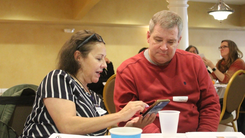 Raquel Martinez, a catechist at Our Lady of Guadalupe in East Chicago, shares a phone app that helps in her ministry with Michael Barron, a catechist at St. Thomas More in Munster. The duo met at the Diocese of Gary's Catechetical Conference hosted by St. Patrick in Chesterton on March 8. (Marlene A. Zloza photo)