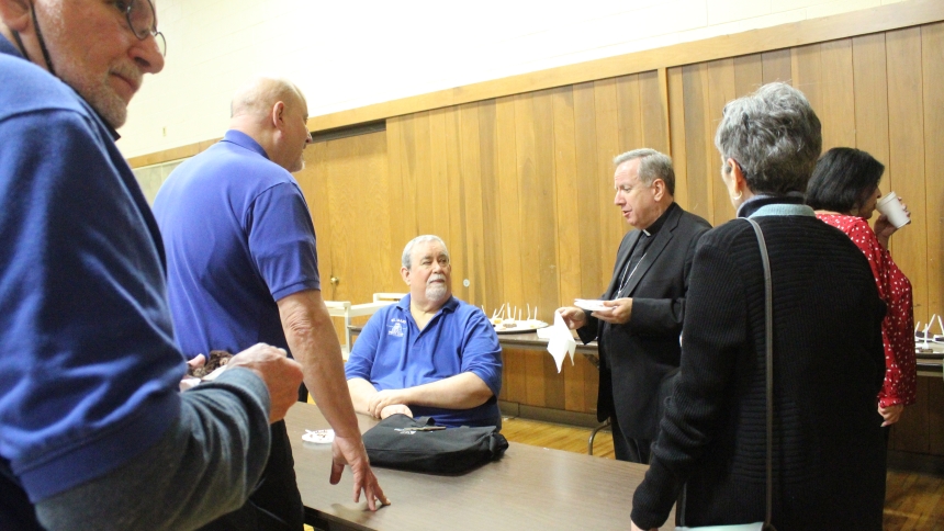 Bishop Robert J. McClory (third from right) meets with Thomas Gora, (seated) president, and other members of the St. Mary Men's Club in Griffith, his hosts, and their guests,  for cake and coffee after his talk about St. Joseph. The group celebrated the Solemnity of St. Joseph after learning about Jesus' foster father and his role as an intercessor for all. (Marlene A. Zloza photo)