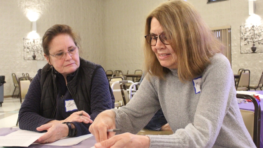 Monica Yacko (right), an adult formation volunteer at Our Lady of Consolation in Merrillville, and attendee Justine Garza, review some of the discussion questions during the sixth session of "The Search," a seven-part video series from the Augustine Institute that is being completed at Our Lady of Consolation on Monday, March 17, at 6:30 p.m. in Vamos Hall. (Marlene A. Zloza photo)