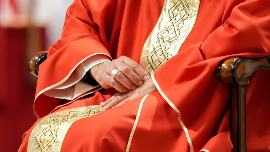 A close-up shows Cardinal Baldassare Reina, papal vicar of Rome, with his hands folded in prayer during the Mass on the third day of the "novendiali," nine days of mourning for Pope Francis, in St. Peter's Basilica at the Vatican April 28, 2025. The Pontifical Missions Societies USA is inviting faithful to pray for a specific cardinal elector who will vote for the next pope in the conclave that begins in Rome May 7, 2025. (CNS photo/Lola Gomez)