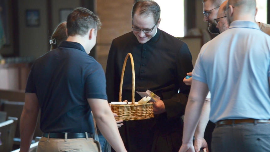 Caption: Father Steven Caraher greets parishioners at Our Lady of Consolation in Merrillville following a Blessing of Easter Baskets on April 19. (Erin Ciszczon photo)