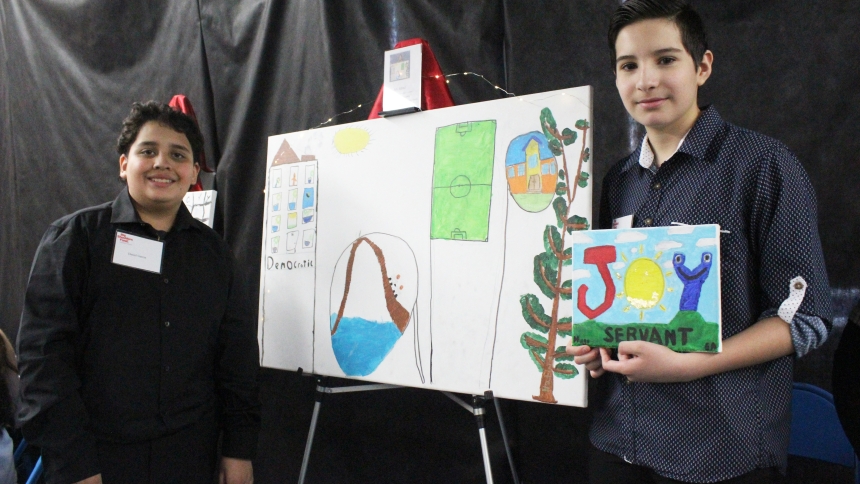 Artists (from left) Daniel Garcia and Hugo Salazar were on hand at St. Casimir School in Hammond to explain the visions they portrayed in their paintings displayed at the Hammond school's Visions of Leadership Art Gala on April 10. Garcia painted the things that make him happy, "soccer, school, nature, roller coasters and my house" while Salazar featured the word "JOY" to explain his feelings about being a "servant leader." (Marlene A. Zloza photo)