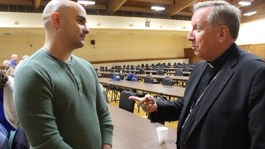 Bishop Robert J. McClory talks with Justin Abascal, an East Chicago firefighter who will receive the sacraments of Holy Communion and confirmation at St. Mary in Griffith on Holy Saturday, April 19. Baptized Catholic as an infant, Abascal has been studying the faith in preparation to become a full member of the Catholic Church at the Easter Vigil Mass. (Marlene A. Zloza photo)