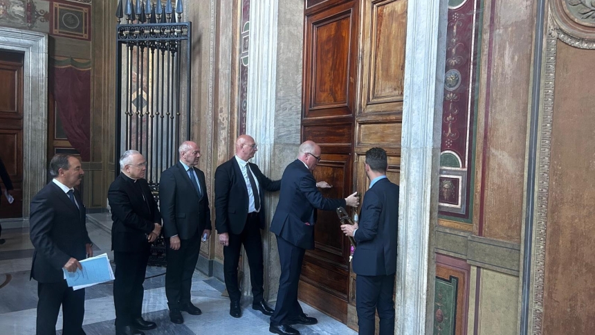 Ranking officers of the Vatican police and the Pontifical Swiss Guard place a beaded rope and seal on a Vatican office in the Apostolic Palace May 6, 2025. Buildings along the path cardinals may take from their residence to the Sistine Chapel during the conclave to elect a new pope have been sealed off. (CNS photo/Vatican Media) Editors: Highest quality available.