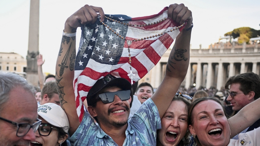 A man holding a rosary and U.S. flag reacts as Cardinal Robert Francis Prevost, who has chosen the papal name Leo XIV, appears on the central balcony of St. Peter's Basilica at the Vatican May 8, 2025, following his election during the conclave. He is the first American pope in history. (OSV News photo/Dylan Martinez, Reuters)