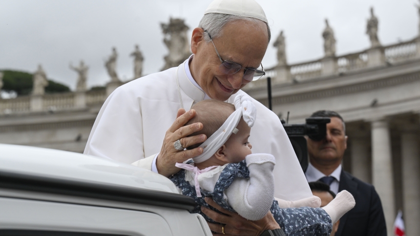 Pope Leo XIV blesses a baby as he rides in the popemobile around St. Peter's Square at the Vatican before his first weekly general audience May 21, 2025. (CNS photo/Vatican Media)