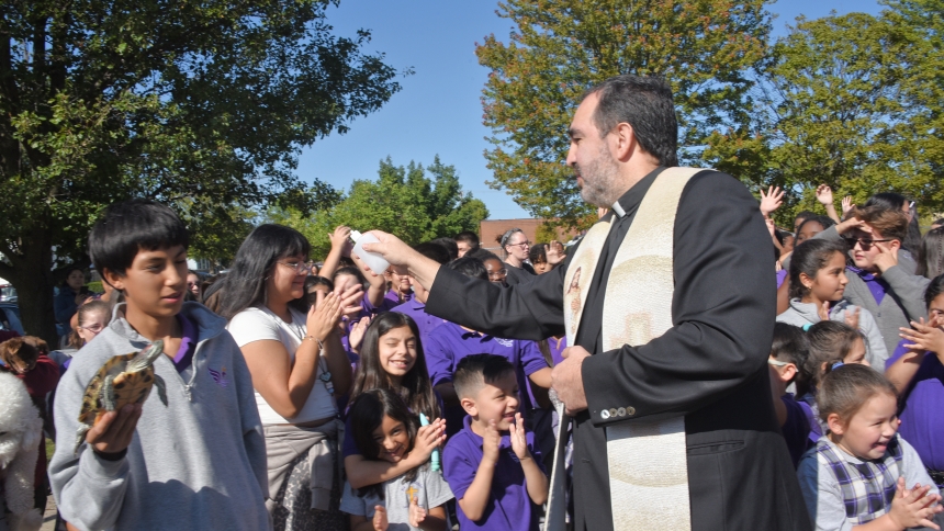 Father Eduardo Malagon (right), pastor, sprinkles holy water on Taki the turtle as his owner Kevin Hernandez, a St. Casimir eighth-grader, holds the reptile at the pet blessing at the Hammond parish on Oct. 4. Prayers reminded the faithful that God is our creator and blesses us with the Earth and its creatures. "May God, who created the animals of this earth as a help to us, continue to protect and sustain us with the grace His blessing brings, now and forever." (Anthony D. Alonzo photo)