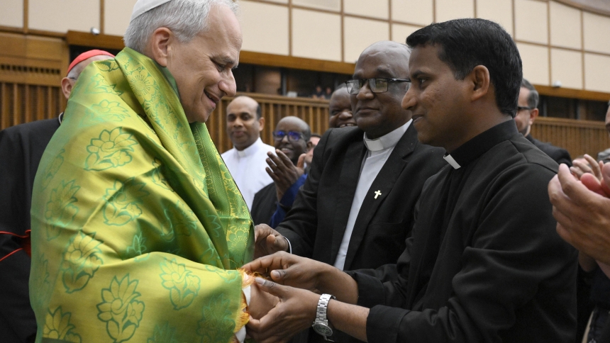 Pope Leo XIV receives a decorative shawl from a priest during a meeting with clergy ministering in the Diocese of Rome in the Paul VI Audience Hall at the Vatican June 12, 2025. (CNS photo/Vatican Media)