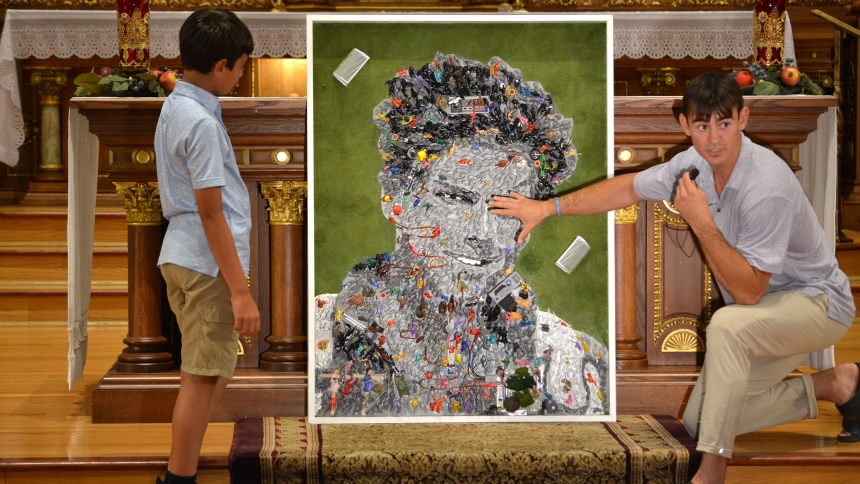 Denver-based multimedia artist Johnny Vrba is pictured inside the St. Hedwig church building of Blessed Carlo Acutis Parish on Chicago's northwest side July 23, 2025. Vrba was answering a boy's questions about a section of a mosaic of Blessed Carlo Acutis he created for the Chicago parish using more than 1,000 toy figurines. (OSV News photo/Simone Orendain)