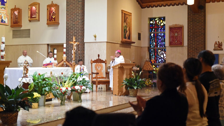 Presider Bishop Robert J. McClory (center) applauds the service of Discalced Carmelite Fathers (at left) during Mass on July 19 at a gathering for the 75th anniversary of the founding of the Carmelite Monastery in Munster. During the World War II era, Polish-native members of the mendicant order of friars arrived in Northwest Indiana to first minister to other Poles, then expanded their sacramental and educational ministry from a beautiful campus at Ridge Road and White Oak Avenue. (Anthony D. Alonzo photo)