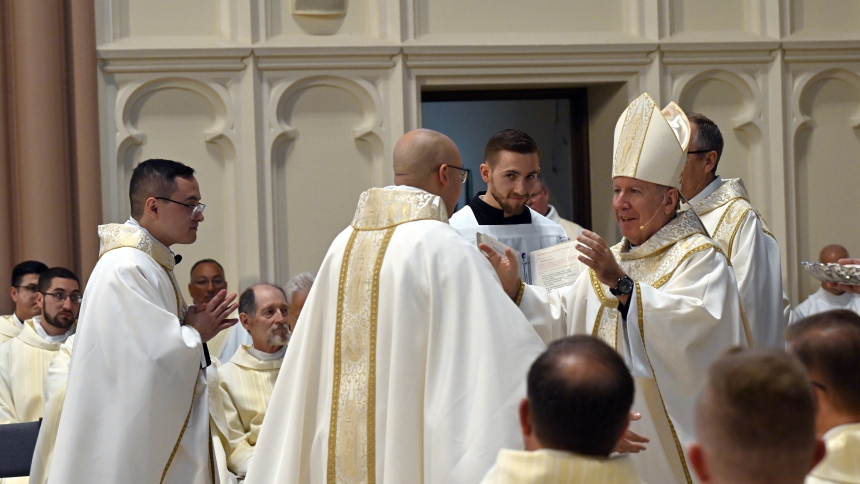 Bishop Robert J. McClory (center, right) prepares to embrace newly ordained Father Alexander Kouris (center) and newly ordained Father Ivan Alatorre (center, left) during the Kiss of Peace at the Mass of Ordination in the Cathedral of the Holy Angels in Gary on June 7. The faithful welcomed the young clergy, who entered new ministries along with transitional Deacon William O’Donnell as "ambassadors of Christ," according to Bishop McClory. (Anthony D. Alonzo photo)