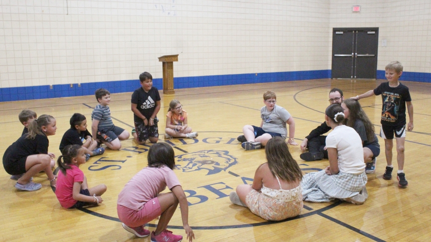 Zach Zeagaczewski taps the heads of fellow players as he rounds the circle in a game of Duck, Duck Goose during the first day of the Totus Tuus program for grades 1-6 at St. Bridget in Hobart on July 7. Faith lessons and prayer are interspersed with games and crafts during the one-week sessions at Diocese of Gary parishes, with four college-age missionaries leading the daytime schedule for grades 1-6 and the evening meetings for grades 7-12. (Marlene A. Zloza photo)
