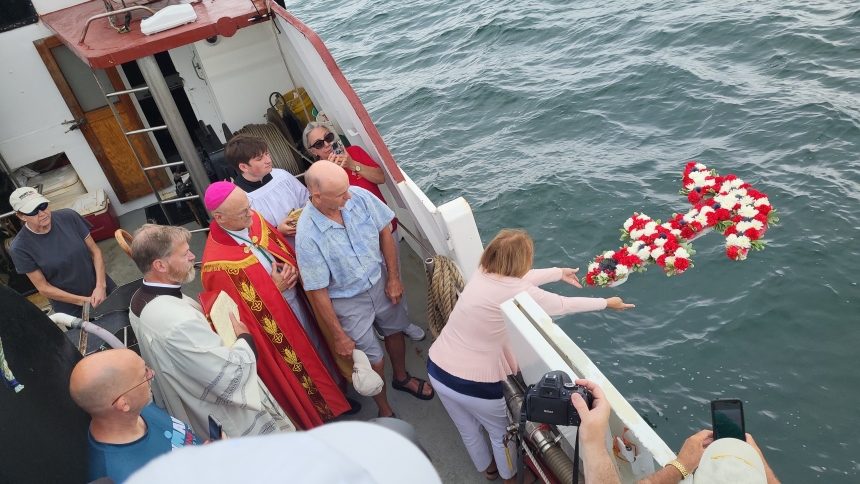 A woman throws a wreath into the water as Bishop Richard F. Reidy of Norwich, Conn., celebrates the Holy Cross Community's annual Blessing of the Fleet in Stonington, Conn., July 27, 2025. (OSV News photo/Ryan Blessing, Four County Catholic)