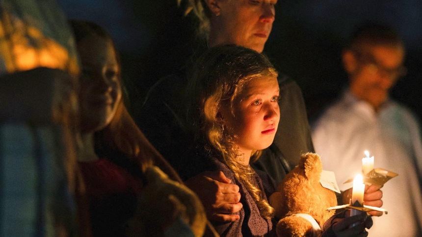 A girl holds a candle during a vigil at Lynnhurst Park in Minneapolis Aug. 27, 2025, following a shooting earlier in the day at Annunciation Church. A shooter opened fire with a rifle through the windows of a the school's church and struck children celebrating Mass during the first week of school, killing two children and wounding 17 people in an act of violence the police chief called "absolutely incomprehensible." (OSV News photo/Tim Evans, Reuters)