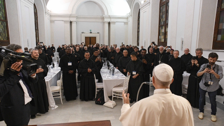 Pope Leo XIV blesses his Augustinian confreres and their meal as he joins them for dinner Sept. 1, 2025, in a hall of the Italian attorney general's office next to the Basilica of St. Augustine in Rome. (CNS photo/Vatican Media)