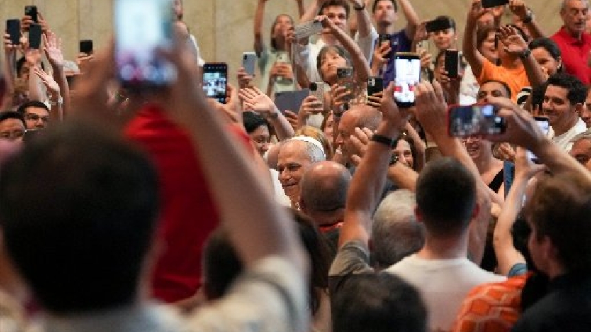 Pope Leo XIV, in choosing a theme for World Communications Day 2026, highlights the need to safeguard human voices and faces in the digital era, ensuring technology like artificial intelligence serves humanity rather than replacing it. In this file photo from June 14, 2025, Pope Leo greets people as they hold up cellphones to take photos and videos as he enters St. Peter’s Basilica for an audience with pilgrims in Rome for the Holy Year 2025. (CNS photo/Lola Gomez)