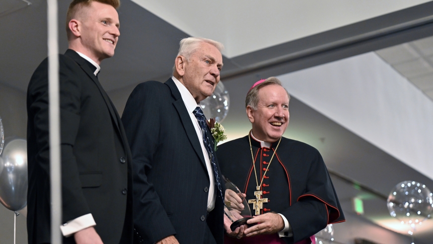 Father Nathaniel Edquist (left) and Bishop Robert J. McClory (right) stand with Guardian Angel Award winner Jack Serletic on stage at the Black Tie White Collar Gala on Sept. 19 at Avalon Manor Banquet Center in Merrillville. The dinner benefit to support those called to the priesthood featured introductions of seminarians, silent and live auctions and music. (Anthony D. Alonzo photo)