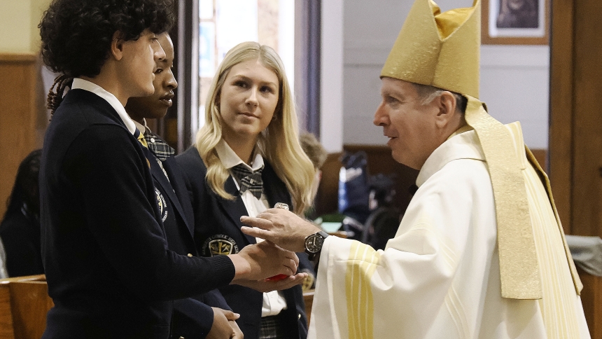 Bishop Robert J. McClory receives the gifts from Marquette students during Mass at St. Mary the Immaculate Conception on Aug. 27. (Deacon Bob Wellinski photo)