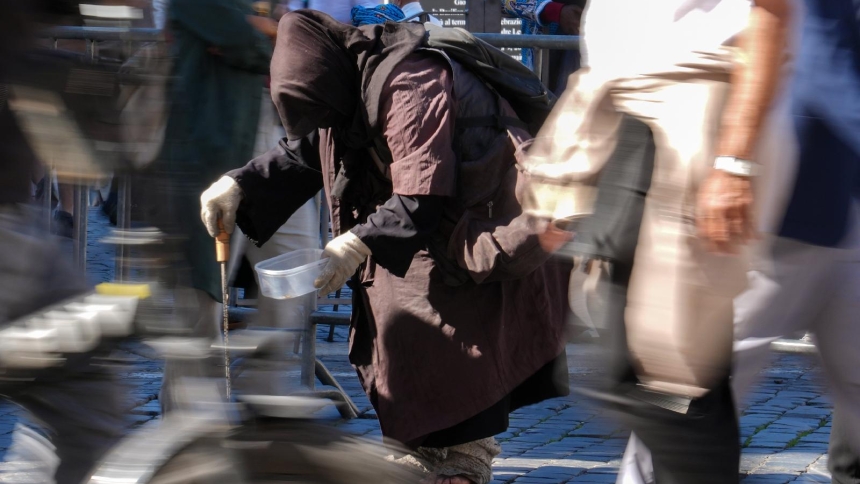 A person asks for alms near St. Peter’s Square at the Vatican Oct. 8, 2025. (CNS photo/Lola Gomez)
