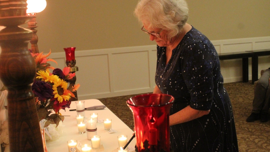 Sharon Staley, a member of Miscarriage Mothers & Others, of Crown Point, lights a candle for a friend’s child at the candlelight vigil hosted by the group on Oct. 15 at Calumet Park Funeral Chapel in Merrillville in honor of the World Day of Remembrance for children who died through miscarriage, stillbirth and as infants. The ceremony was repeated at 7 p.m. local time throughout the world as families gathered to mourn their lost members and celebrate their lives. (Marlene A. Zloza photo)