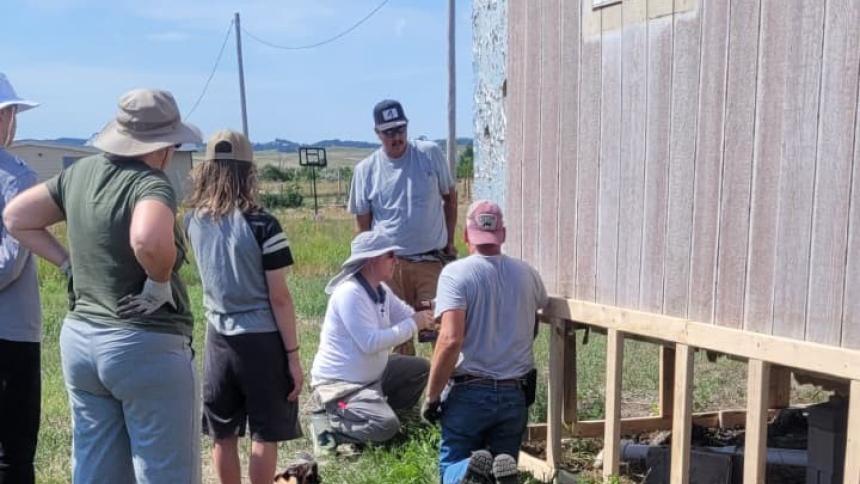 Working on trailer skirting during their mission trip to Pine Ridge Reservation in southwest South Dakota last summer are One Catholic Family parishioners (from left) Rochelle McNamara, Paul Yankauskas, James Yankauskas and Leon Pawlowski. Photos from the trip were shared during a luncheon for supporters hosted on Sept. 14 at St. Helen in Hebron, which organized the trip. (Provided photo)