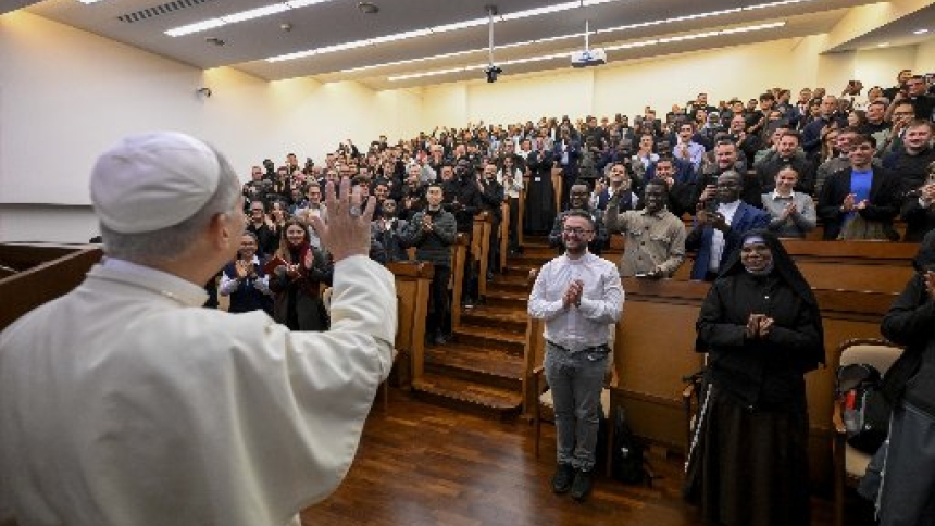 Pope Leo XIV waves to students in a lecture hall at Rome's Pontifical Lateran University after giving a formal speech to professors, staff and a small group of students in the university's main hall Nov. 14, 2025. (CNS photo/Vatican Media)