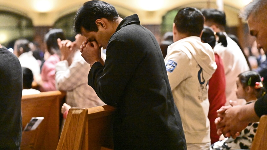 A man bows his head in prayer among the hundreds of worshippers at the one-year anniversary Mass for Vietnamese Catholics at St. Michael the Archangel in Schererville on Nov. 2. Coordinated by those sharing the Southeast Asian heritage, the liturgy presided over by Bishop Robert J. McClory was part of an evening that included an ethnic dinner and customary entertainment in celebration of the establishment of a monthly Vietnamese language Mass at the parish. (Anthony D. Alonzo photo) 