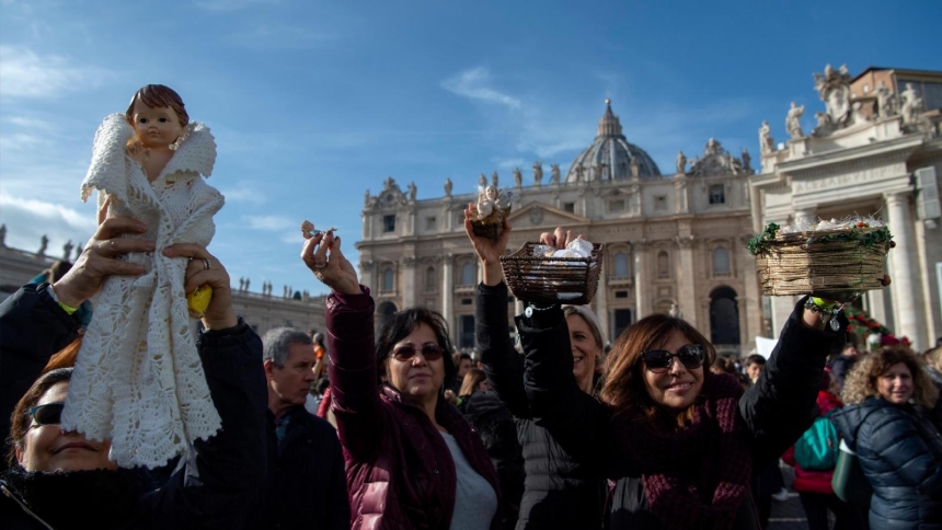 Pilgrims hold up figurines of the Christ Child as Pope Francis leads the Angelus from the window of his studio overlooking St. Peter's Square at the Vatican Dec 15, 2019. (CNS photo/Vatican Media) See POPE-ANGELUS-BAMBINELLI Dec. 16, 2019.