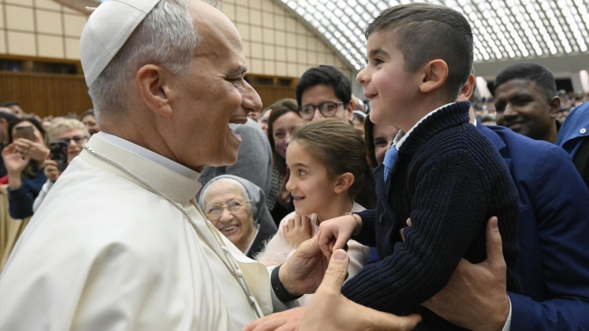 Pope Leo XIV greets a child after his after his annual pre-Christmas meeting with Vatican employees and their families in the Paul VI Audience Hall at the Vatican Dec. 22, 2025. (CNS photo/Vatican Media)