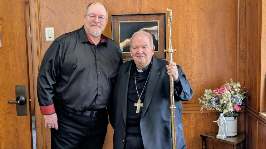 Jeff Helgeson poses with Bernard Hebda, who is holding the crosier Helgeson found in a scrapyard, during their May 30, 2025, meeting at the Archdiocesan Catholic Center in St. Paul. Finding the crosier has drawn Helgeson into a journey back to the Catholic Church of his youth. (OSV News photo/courtesy Paul Lovino)