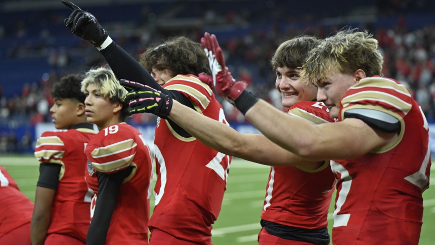 Andrean High School juniors Bruce Moorhouse (third from left), Brady Quinn (second from right) and Mitchell Myers (right) wave to fans at the conclusion of the Class 2A state football championship game where the 59ers defeated the Braves 7-0 at Lucas Oil Stadium in Indianapolis on Nov. 29. Local fans traversed snowy conditions to see the 59ers earn their fourth state championship and first since 2021, thereby getting bumped up from Class 2A to Class 3A for future football scheduling by the Indiana High Scho
