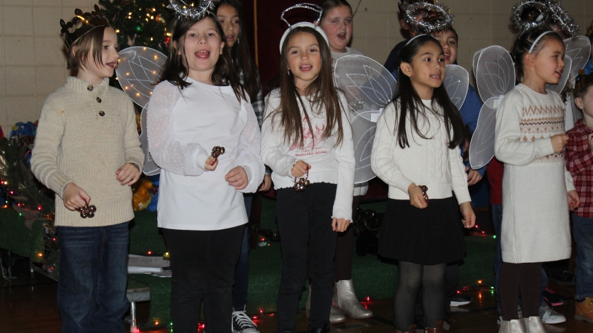 Children in religious education classes at St. Bridget, kindergarten through fifth grade, shake bells as they sing a rousing version of “Jingle Bells” at the Hobart parish’s Christmas party on Dec. 20. Close to 200 parishioners and their guests enjoyed a bountiful potluck dinner and holiday entertainment, including a visit from Santa Claus. (Marlene A. Zloza photo)