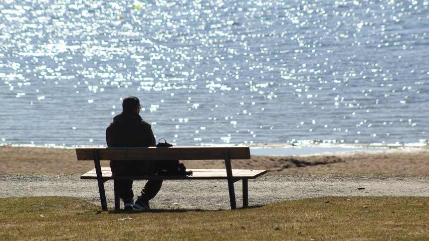 Man sitting on bench overlooking water