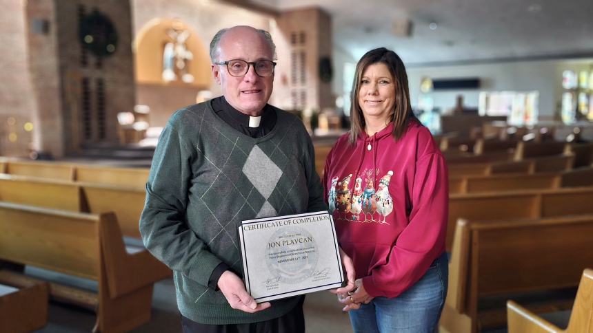 Father Jon Plavcan, pastor of St. Patrick Catholic Community, and Susan Hadenfelt, St. Patrick School principal, pose together with Father Plavcan’s certificate he received after the pair completed Chesterton Police Department’s Citizens Police Academy. (Deacon Bob Wellinski photo)
