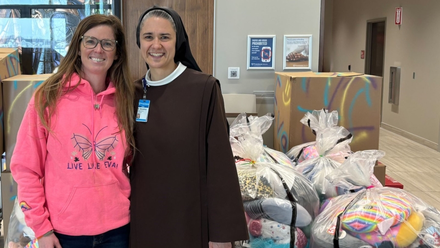 Rebekah Martin and Sister Benedicta stand by bags containing 1,500 stuffed animals donated to Franciscan Health by The Eva Martin Project, founded in memory of Rebekah’s daughter.