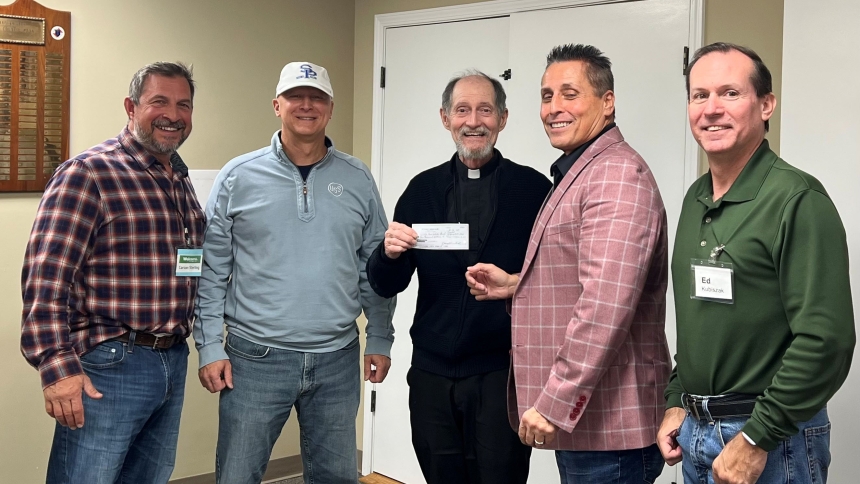 St. Paul Men's Club board members present Father Doug Mayer with a $10,000 donation to the church