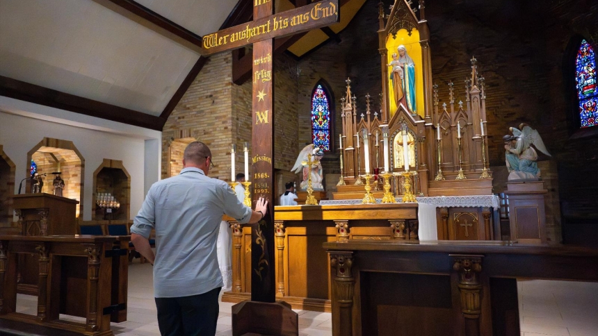 A worshipper venerates the Jubilee Mission Cross used during a 2025 Jubilee Year procession at the National Shrine of Champion in Champion, Wis., July 20. Jesuit Father Francis Xavier Weninger, a pastor to German Catholics in Green Bay in the 1800s, erected mission crosses in each parish he visited, including the one used for the procession. The cross is inscribed with the message: "He who perseveres will be blessed forever." (OSV News photo/Sam Lucero)