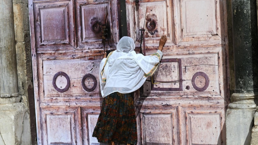 An Ethiopian Christian woman prays at the locked doors of the Church of the Holy Sepulcher in the Old City of Jerusalem March 4, 2026, on day five of the U.S.-Israel war with Iran. The church and other religious sites as well as stores were locked shut by order of the Israeli government as Iranian ballistic missiles were fired at Israel. (OSV News photo/Debbie Hill)