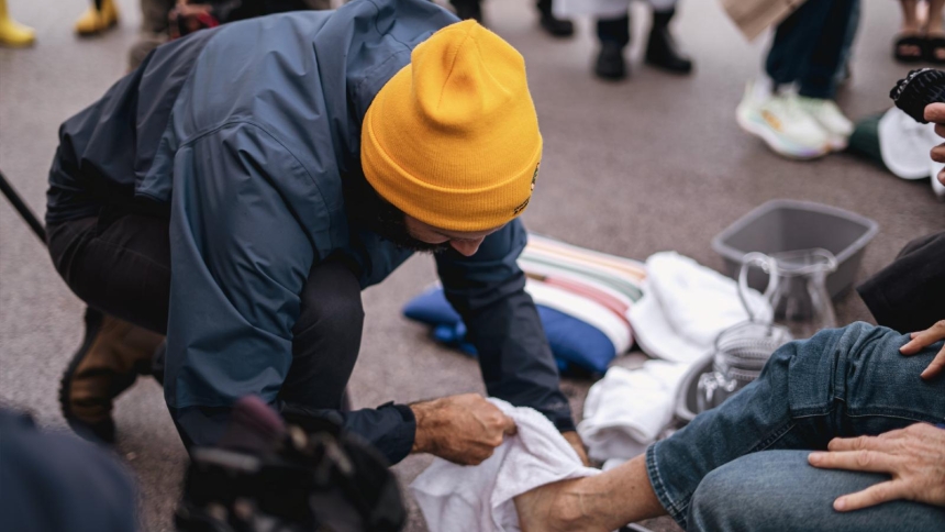 Michael Okinczyc-Cruz, executive director of the Coalition for Spiritual and Public Leadership, washes the feet of an immigrant on Holy Thursday, half a block away from the Broadview ICE processing facility in Broadview, Ill., as three priests and a religious sister minister to 14 people detained at the ICE facility April 2, 2026. (OSV News photo/courtesy of Coalition for Spiritual and Public Leadership)