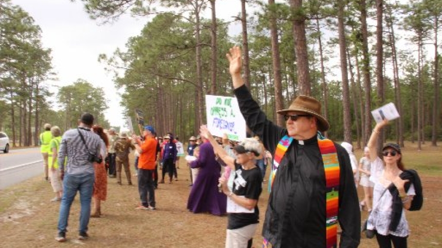 Immigrant advocates, including the Rev. Russell l. Meyer, executive director of the Florida Council of Churches, center front, wave on Good Friday, April 3, 2026, to detainees housed at Deportation Depot in Sanderson, Fla., which formerly served as Baker Correctional Institution. (OSV News photo/Jean Gonzalez, Florida Catholic)
