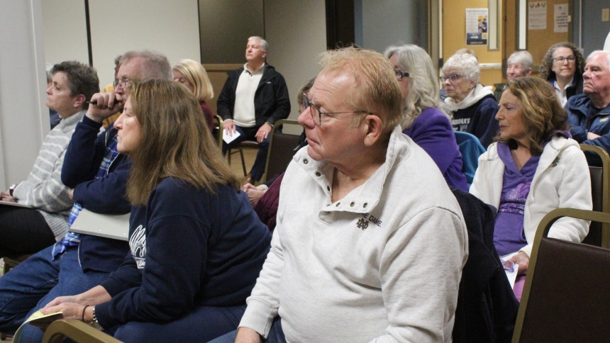 Pamela and Paul Thomas, parishioners at St. Teresa of Avila Catholic Student Center in Valparaiso, listen to staff members from Bartholomew Funeral Home discuss the benefits of advance planning when it comes to funerals. They were among a standing-room-only crowd attending the End of Life Planning program hosted at St. Teresa of Avila Catholic Student Center in Valparaiso on April 1.  (Marlene A. Zloza photo)