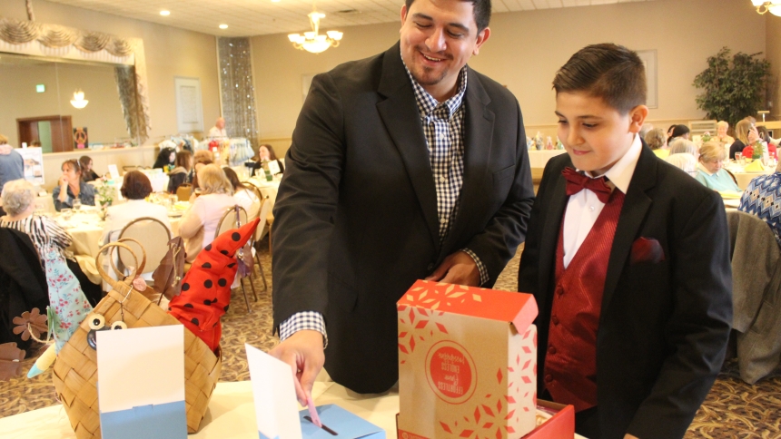 Jordan Al-Akel and his son, Alek distribute their raffle tickets, hoping to win a prize, at the Spirit of Spring Fashion Show hosted by the Parish Life Committee at Our Lady of Grace in Highland, on April 26 at Andorra Banquets in Schererville. Alek, a fourth grader at Southridge Elementary School in Highland, modeled the tuxedo he is wearing. (Marlene A. Zloza photo)
