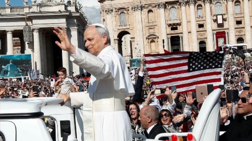 An American flag is displayed as Pope Leo XIV, formerly Cardinal Robert F. Prevost, waves as he arrives to celebrate his inauguration Mass at the Vatican May 18, 2025. He is the first American pope in history. (OSV News photo/Andy Abeyta, Reuters)