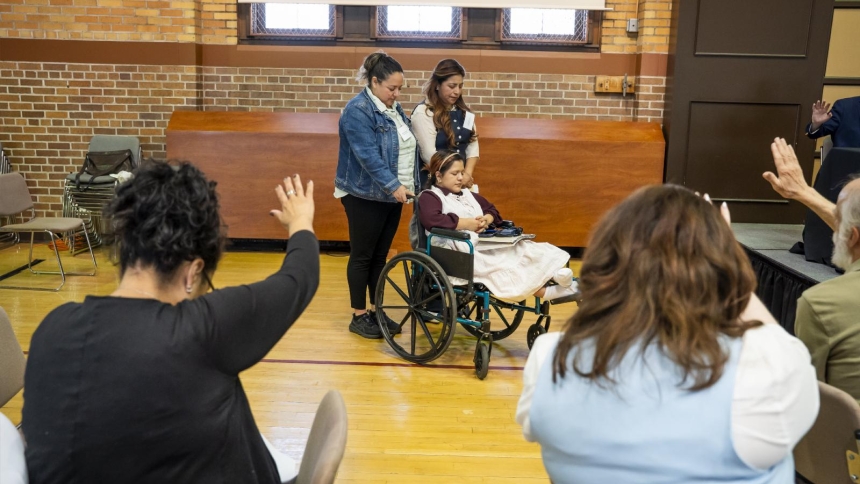 Participants of the "Witness to Hope: Pastoral Care of Immigrant Communities" summit at Sacred Heart Major Seminary in Detroit May 6, 2026, pray over Daris Bartolon and her daughter, Maddeline. Daris and her daughter fled their native Guatemala in order to get away from her domestic abuser. She has a court date June 1 to hear her plea for asylum. (OSV News photo/Valaurian Waller, special for Detroit Catholic)
