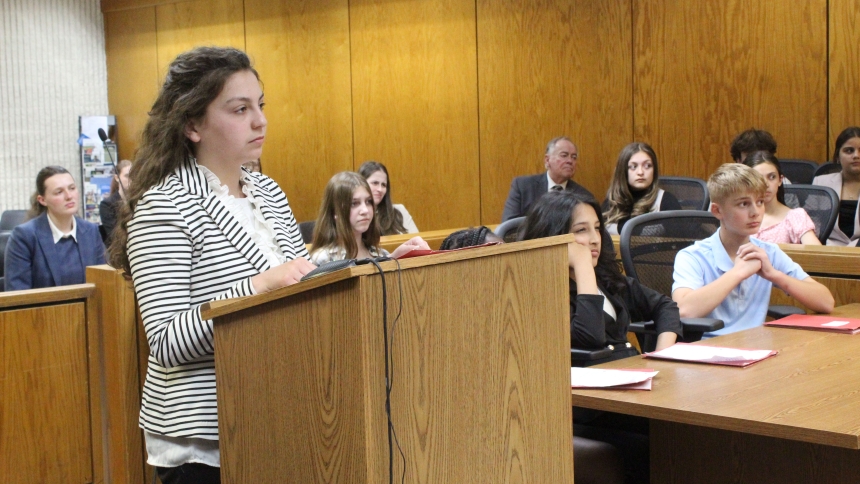 With fellow “defense attorneys” and the real attorneys who mentored students watching, seventh-grader Annabella Chase of Brittany LaMere’s class at St. Mary School, Crown Point,  cross examines the victim in a mock trial held in Judge Julie N. Cantrell’s Lake Superior Court on May 20 at the Lake County Courthouse in Crown Point. The trial was the culmination of a year-long program teaching junior high students about the legal system, sponsored at St. Paul School in Valparaiso and St. Mary School by Big Shou