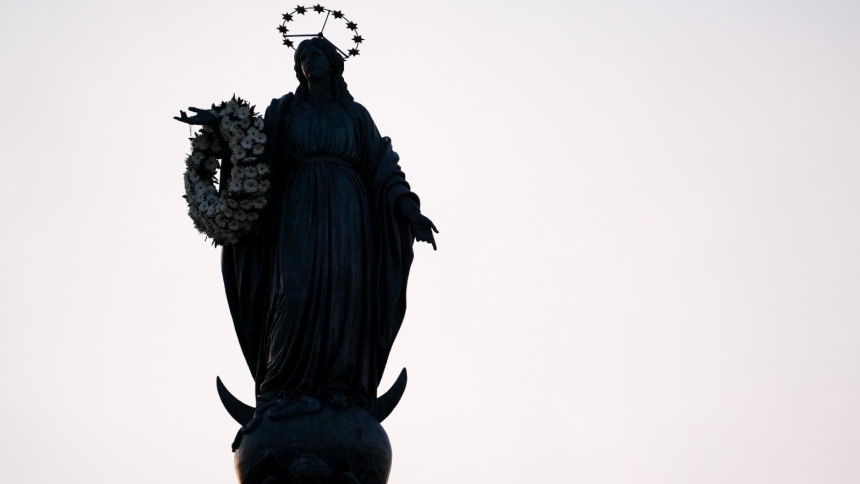 A silhouette of the Marian statue near the Spanish Steps in Rome is seen after a firefighter placed a wreath of flowers on the statue's arm Dec. 8, 2025, the feast of the Immaculate Conception. (CNS photo/Lola Gomez)