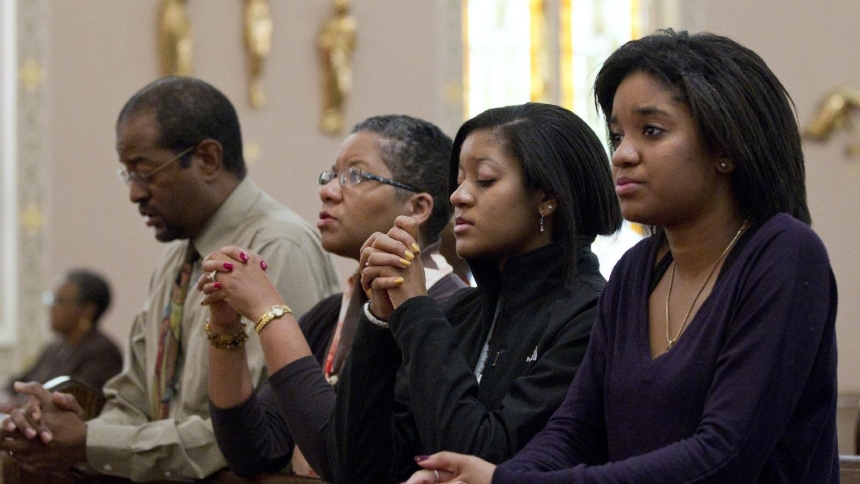 A family is pictured in a file photo praying before Mass. (OSV News photo/Nancy Phelan Wiechec)