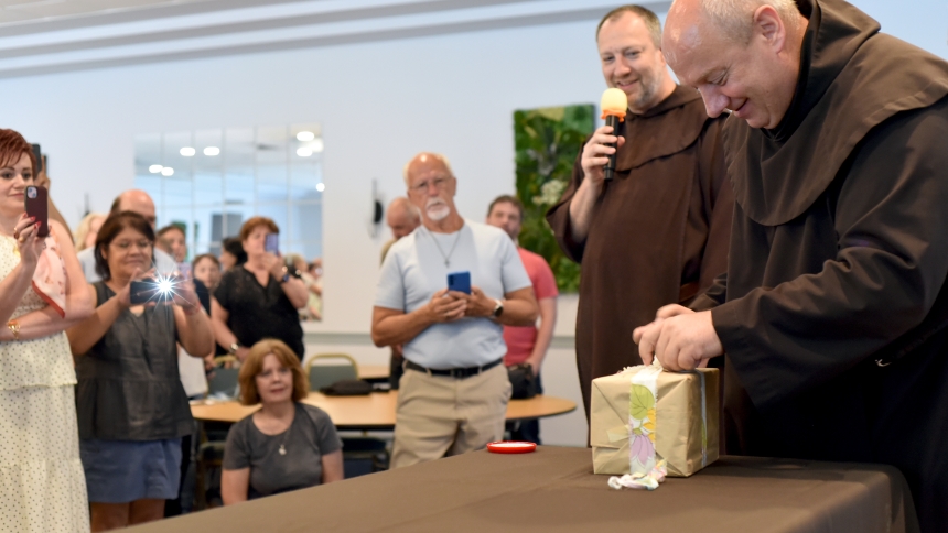 Father Franciszek Czaicki (right), OCD, unwraps an unearthed package as Father Andrzej Gbur (back), OCD, looks on at the opening of a 50-year time capsule on July 12 at the Carmelite Monastery in Munster. Well-preserved artifacts such as photos, papers and coins were discovered in the steel case, originally buried on the nation’s bicentennial in 1976. (Anthony D. Alonzo photo)